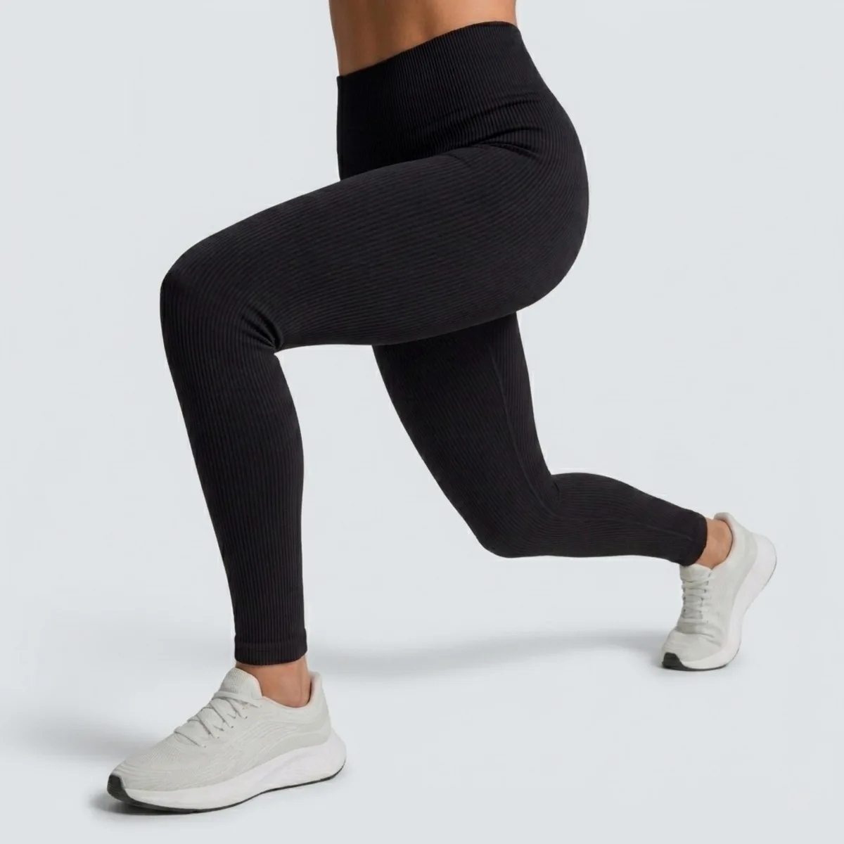 Mulher fazendo afundo com a legging canelada preta